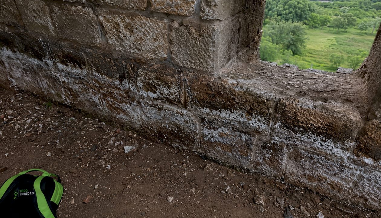 Se observa humedad en el interior del muro de piedra, lo que podría indicar filtraciones o problemas de aislamiento.