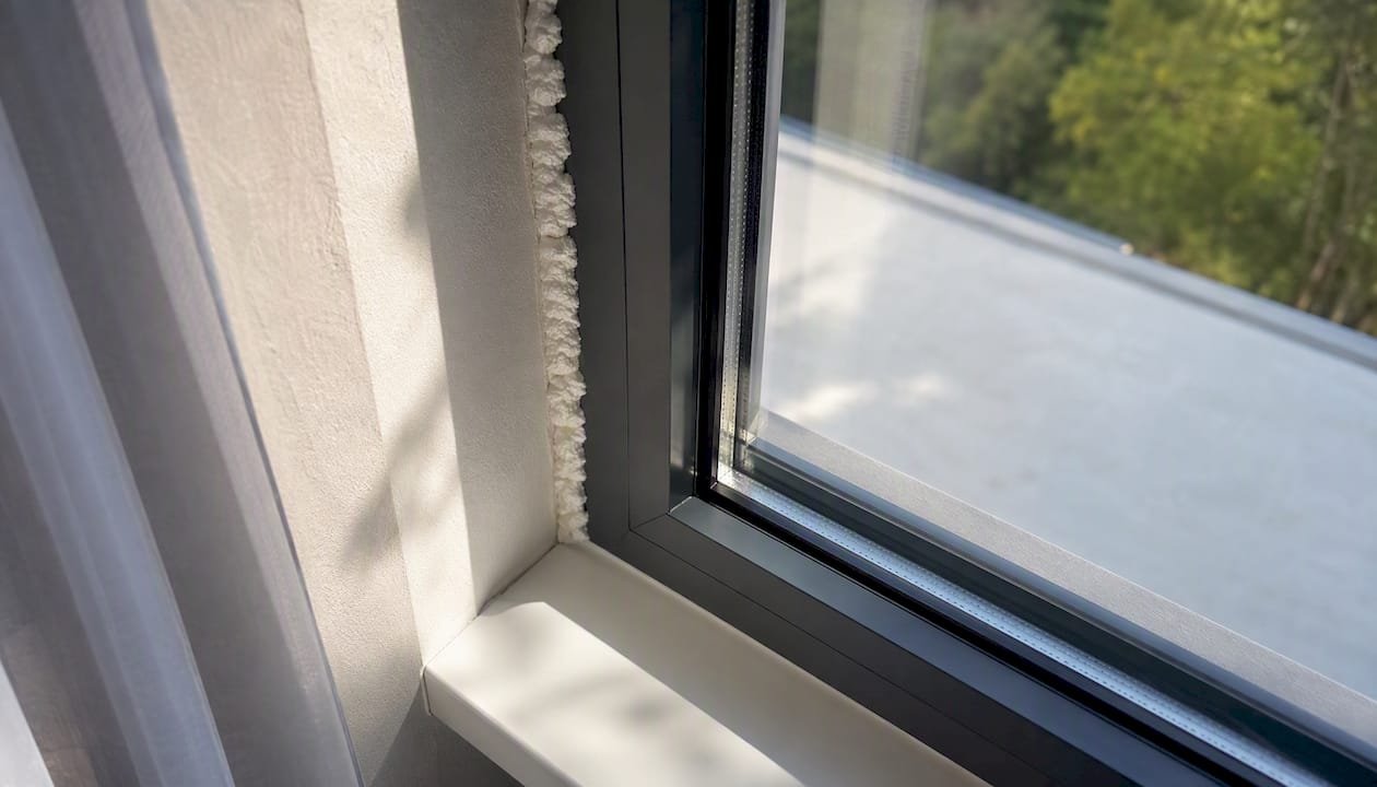 Detalle en primer plano de una sección de perfil de ventana con aislamiento