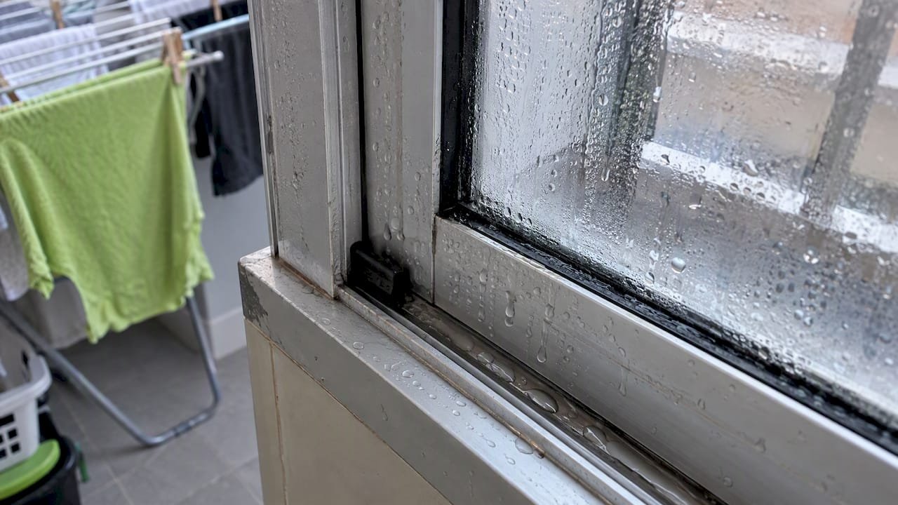 Condensación en el marco y riel de la ventana corrediza
